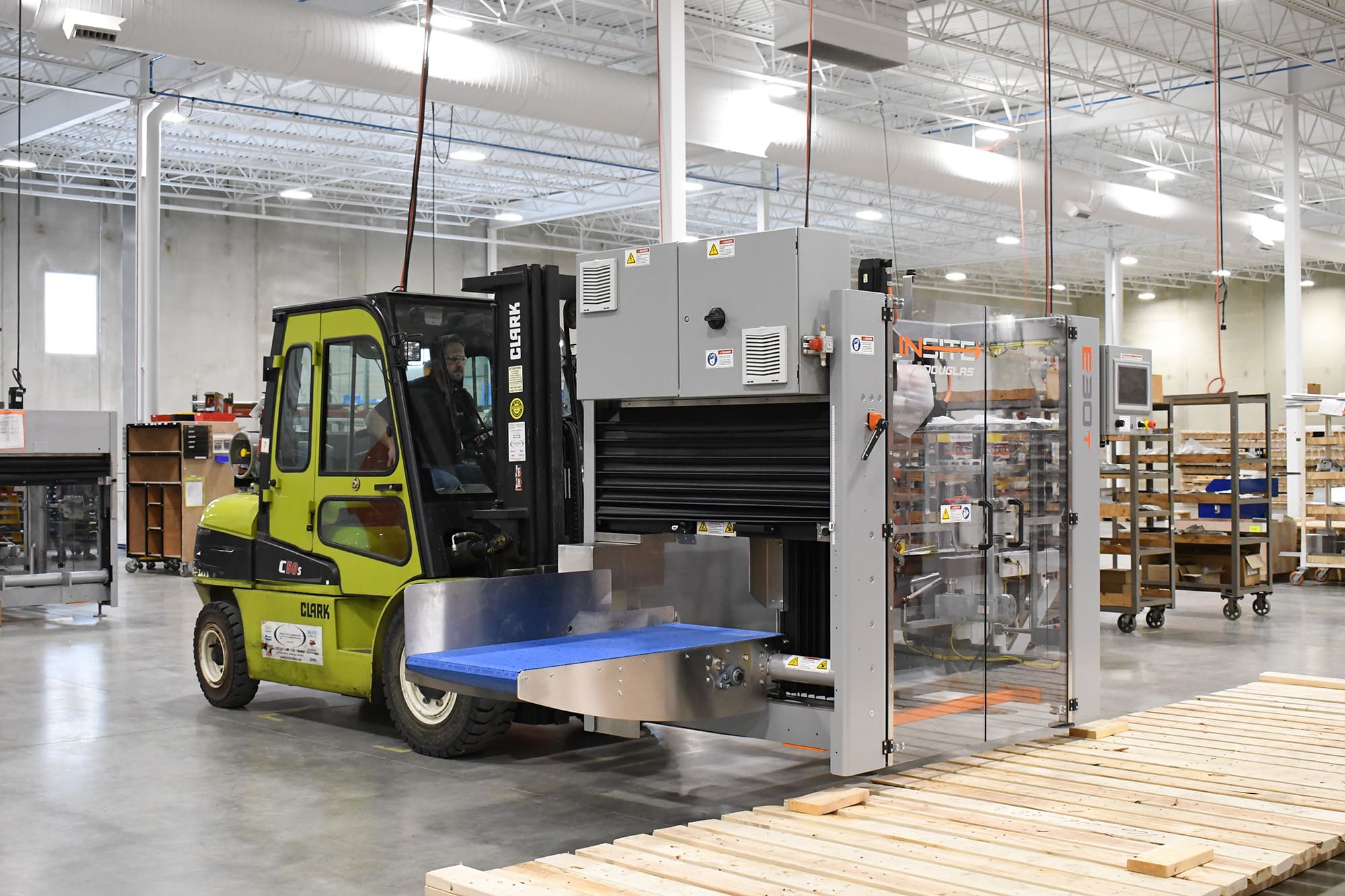 Forklift carrying INSITE case erector in warehouse
