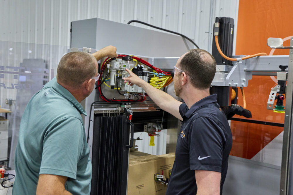 Two INSITE technicians looking at the wiring of a machine